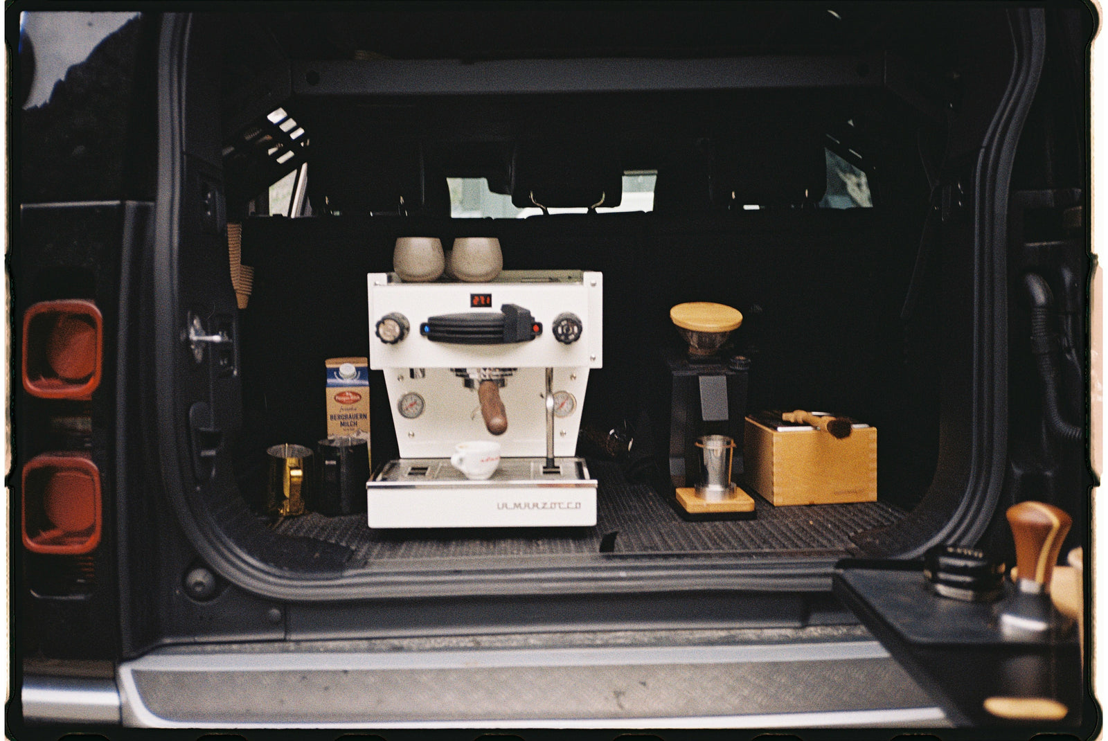 La Marzocco Espresso machine and coffee-making accessories in the back of a vehicle