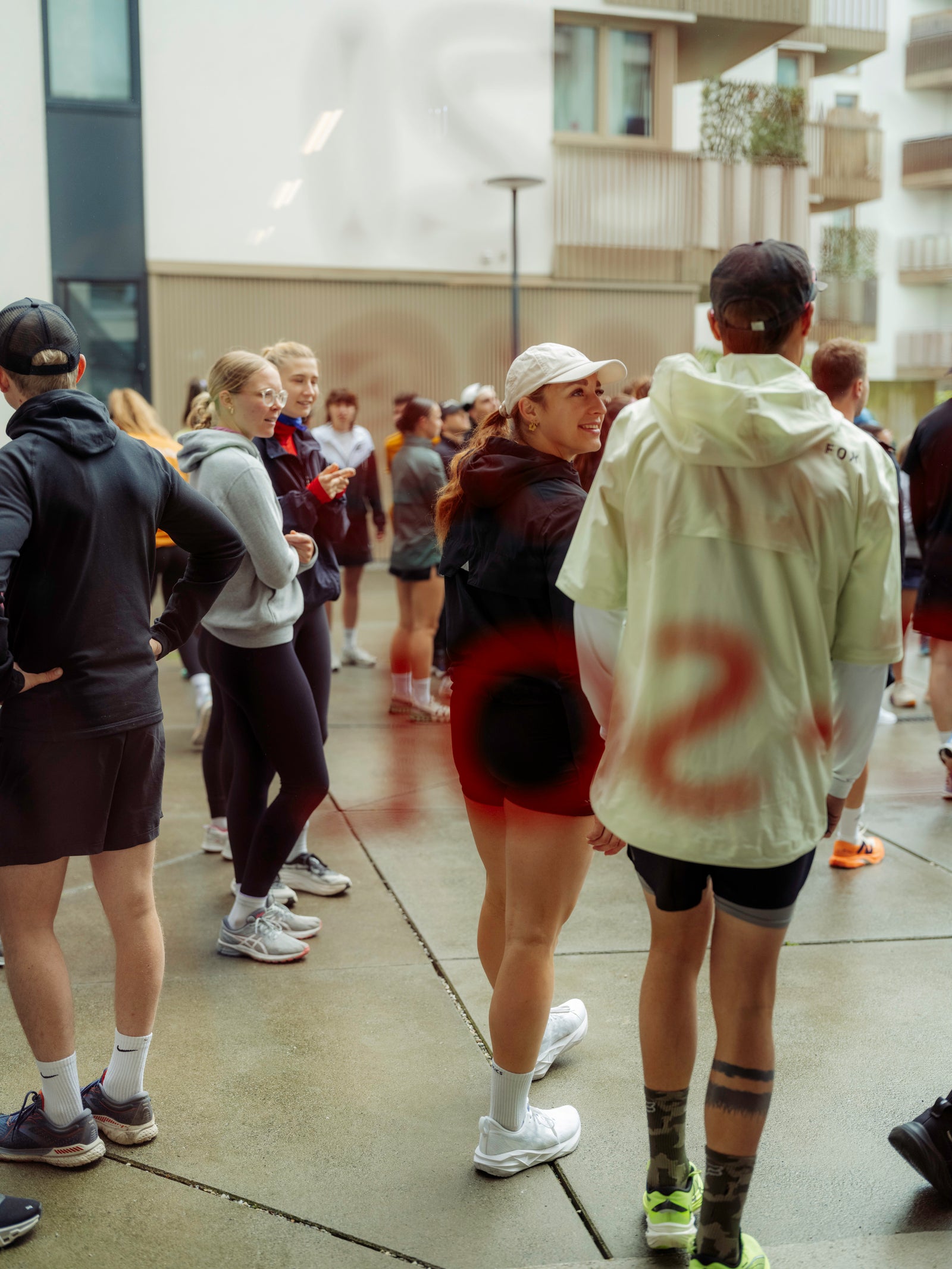 Group of people from a runclub standing on a sidewalk, wearing athletic gear.