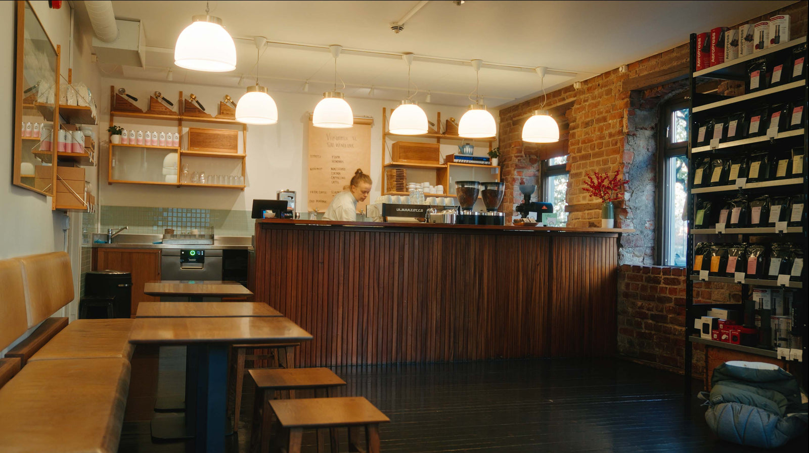 Interior of a Tim Wendelboe coffee shop with wooden furniture and shelves.