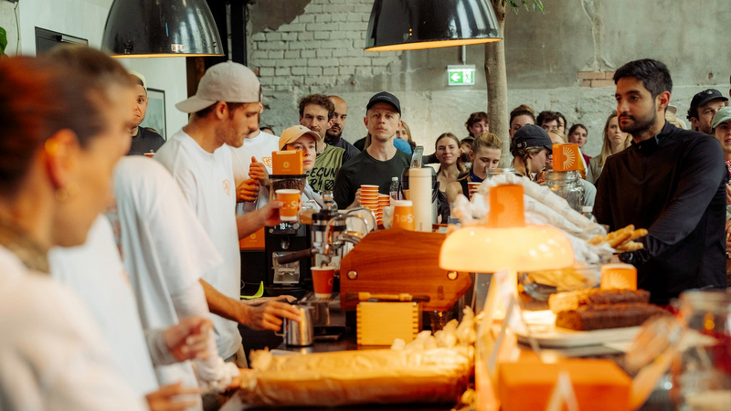 People gathered around a counter with food and drinks in a casual setting